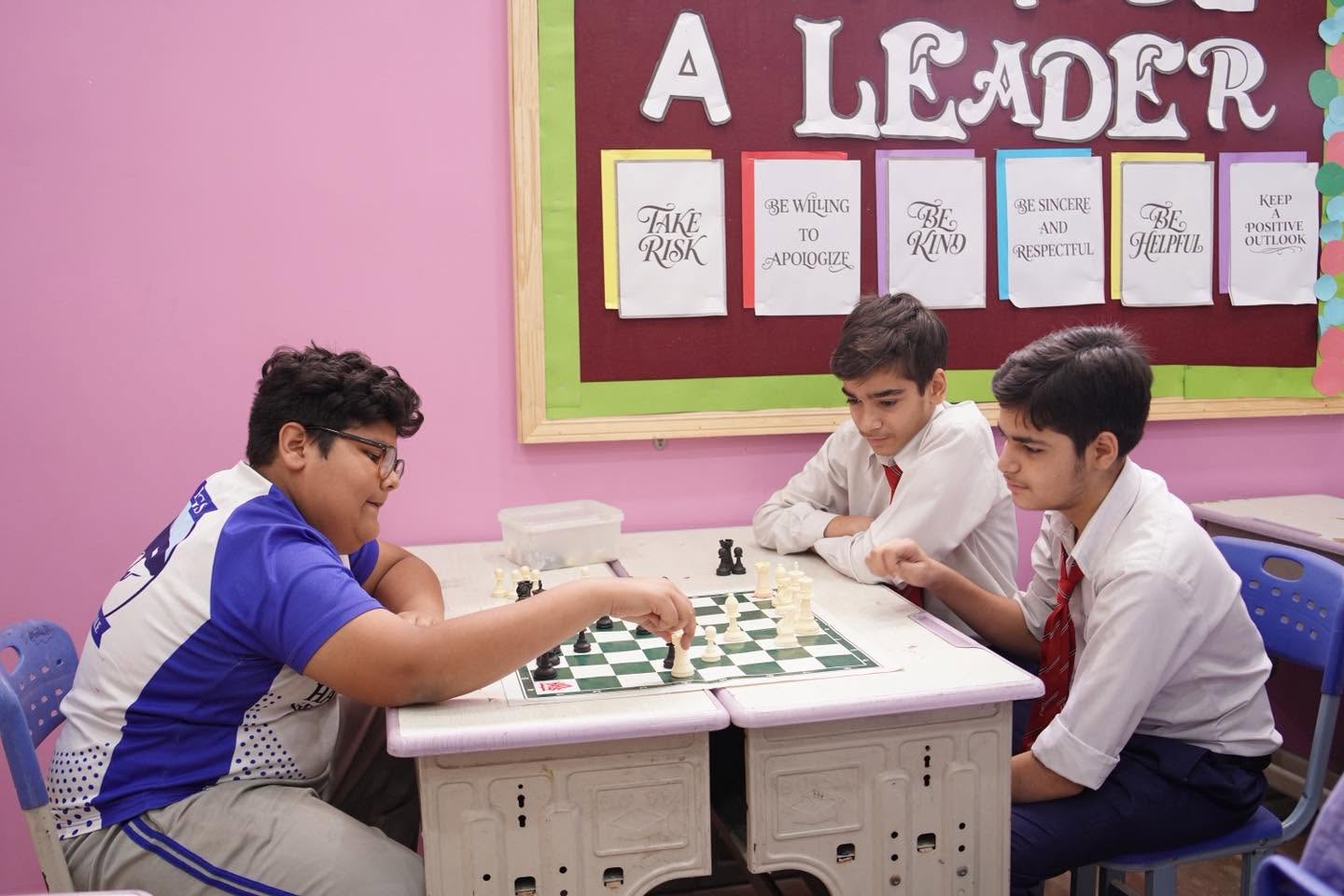 A student making a chess move during a friendly match