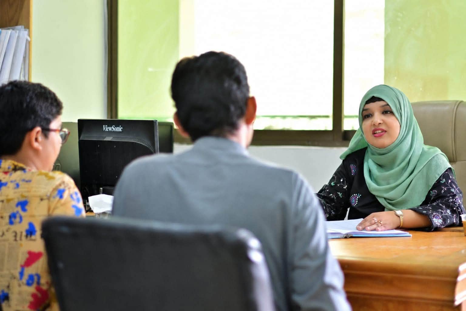 A teacher speaking with a family during an HPGS academic orientation meeting