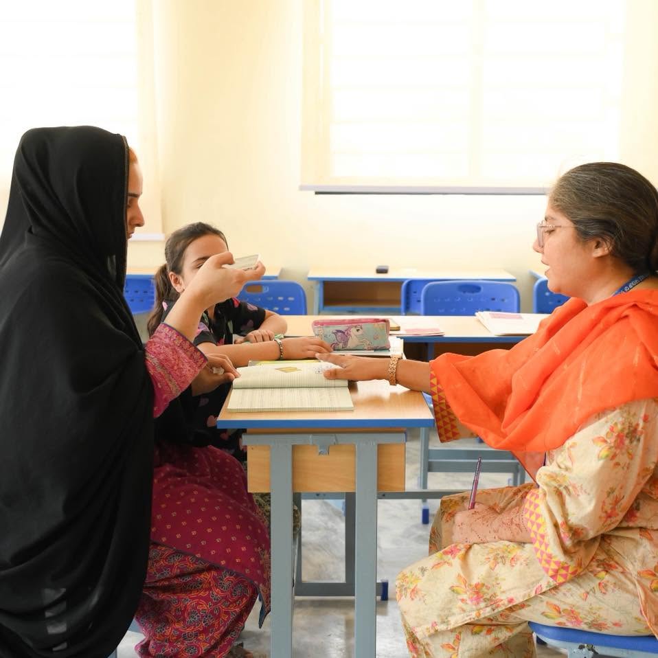 A parent and teacher discussing a child’s learning in an HPGS classroom