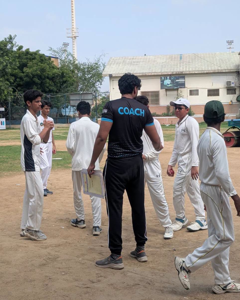 HPGS cricket students gathered with their coach during the trial session