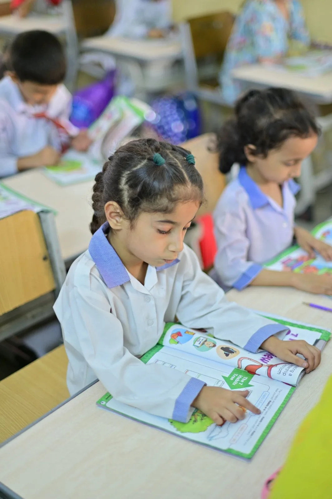 Primary Years student reading a LIM workbook at her desk
