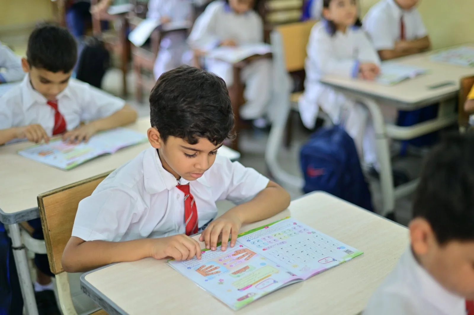 Primary Years student concentrating on a lesson workbook